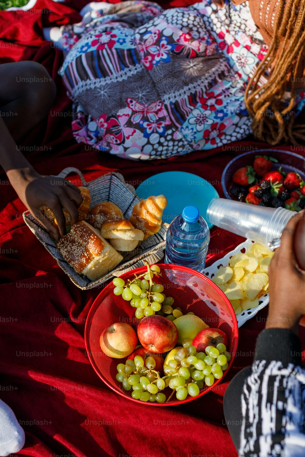 a person sitting on a blanket with a plate of food