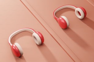 분홍색 표면에 빨간색과 흰색 헤드폰 한 쌍