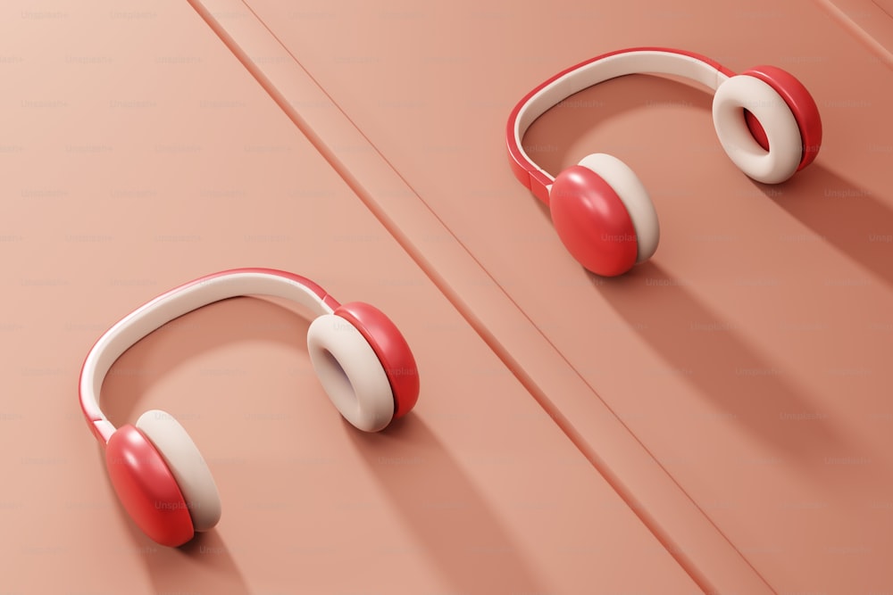 a pair of red and white headphones on a pink surface