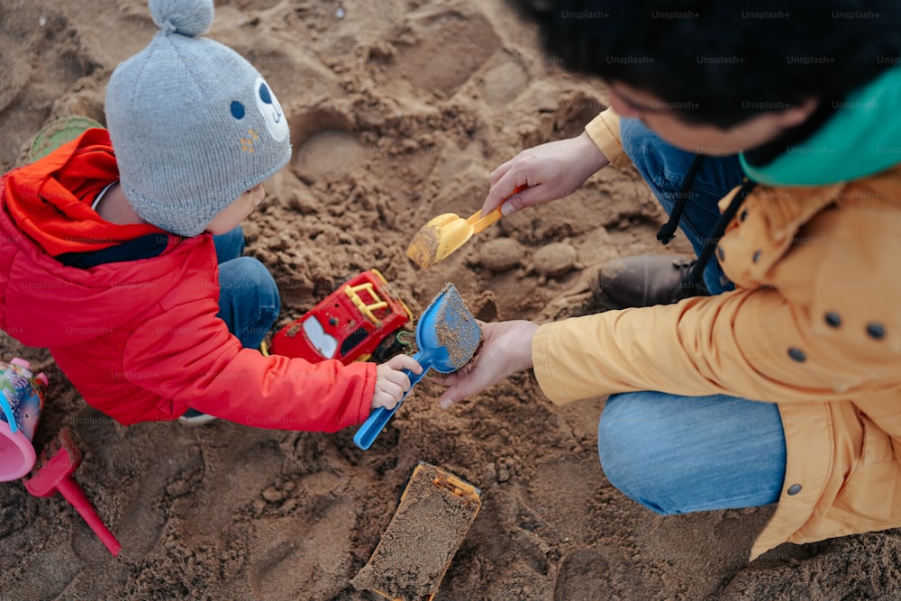 Un hombre y un niño jugando en la arena