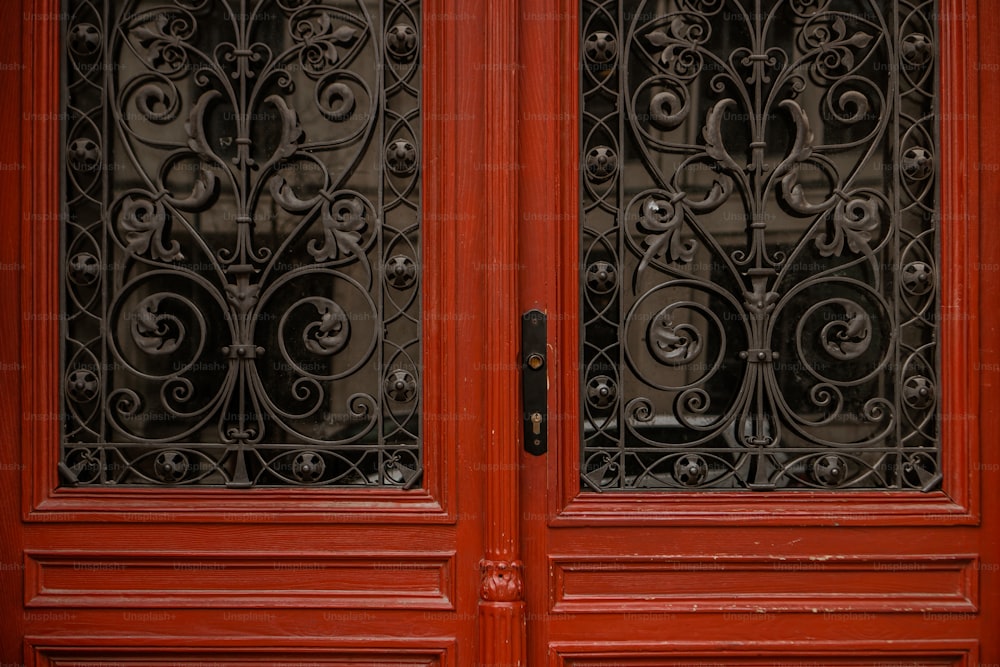 a close up of a red door with wrought iron