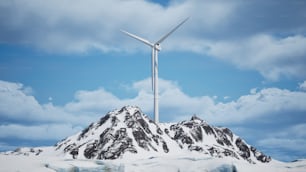 a wind turbine on top of a snow covered mountain