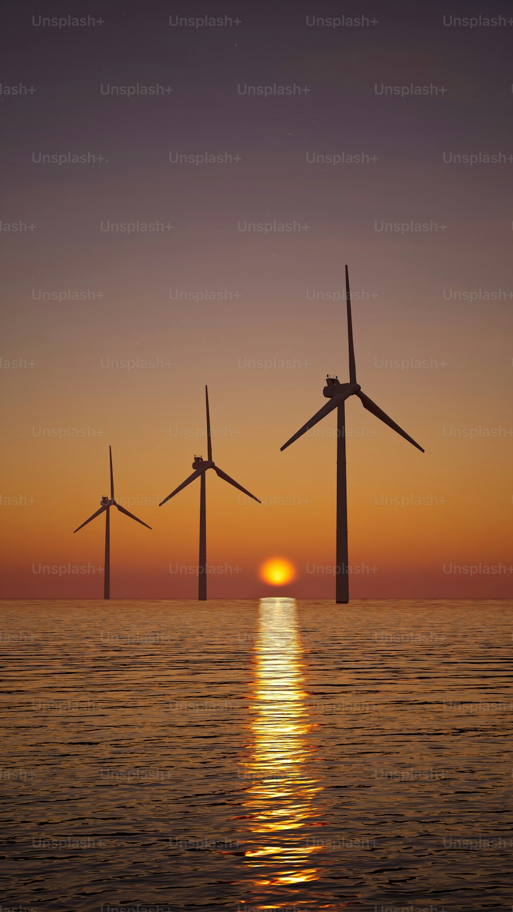 a group of windmills floating in the ocean at sunset