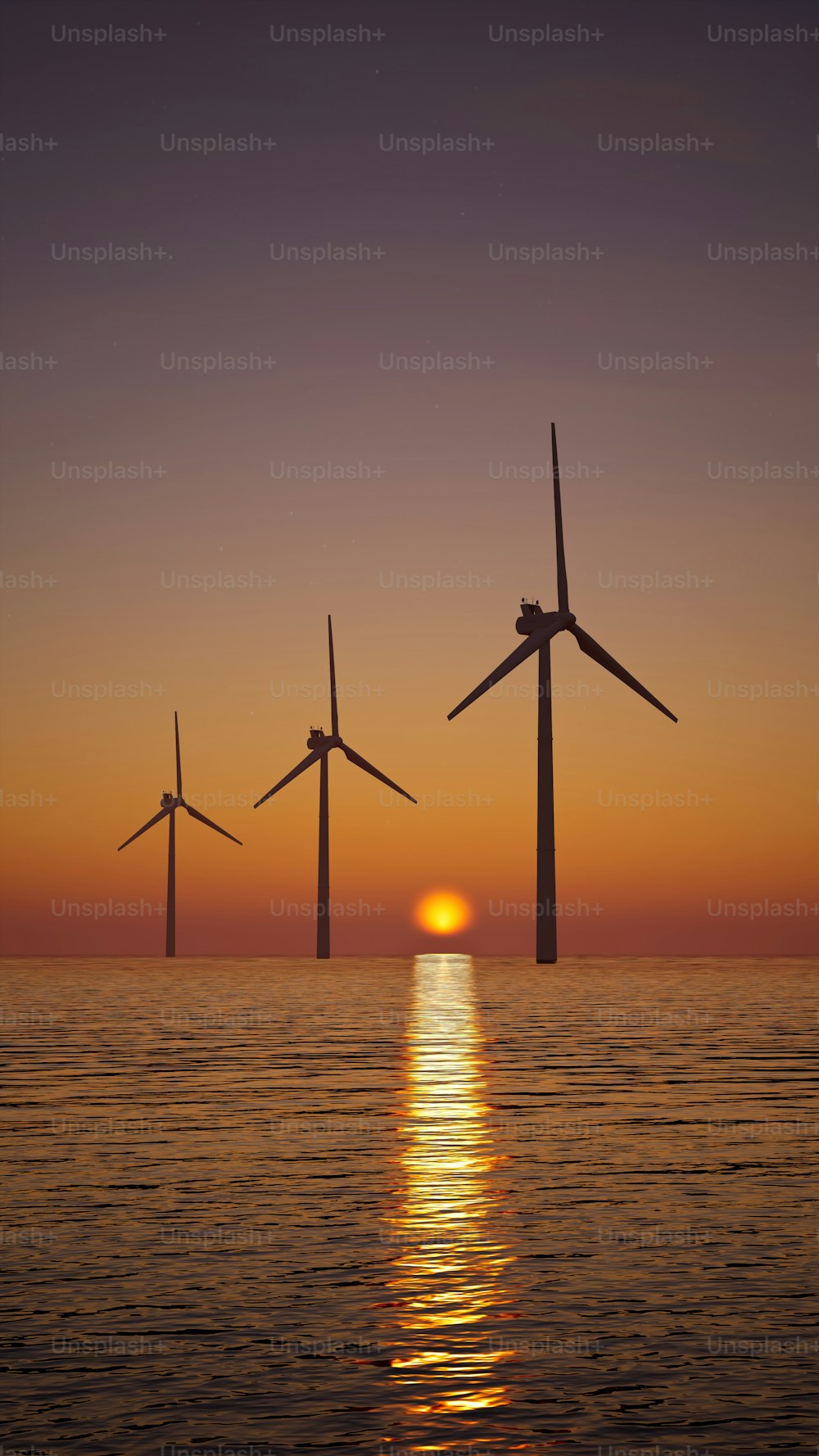 um grupo de moinhos de vento flutuando no oceano ao pôr do sol