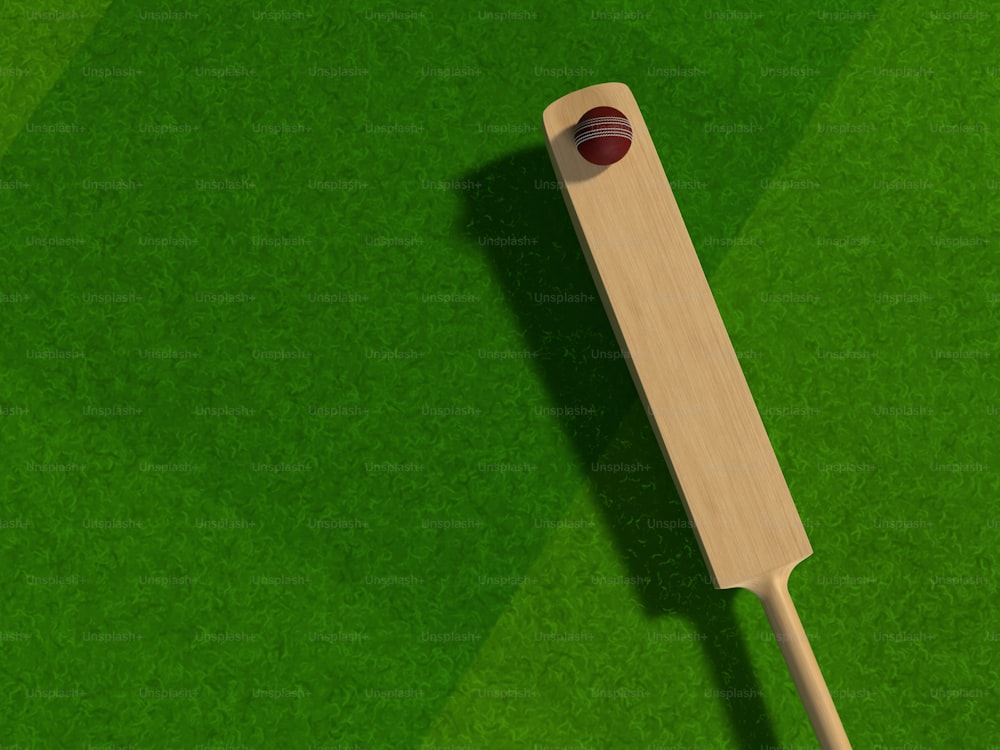 緑のフィールドに置かれた木製�の野球のバット