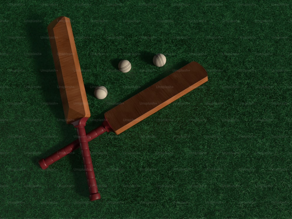 a wooden bat and three balls on a green surface