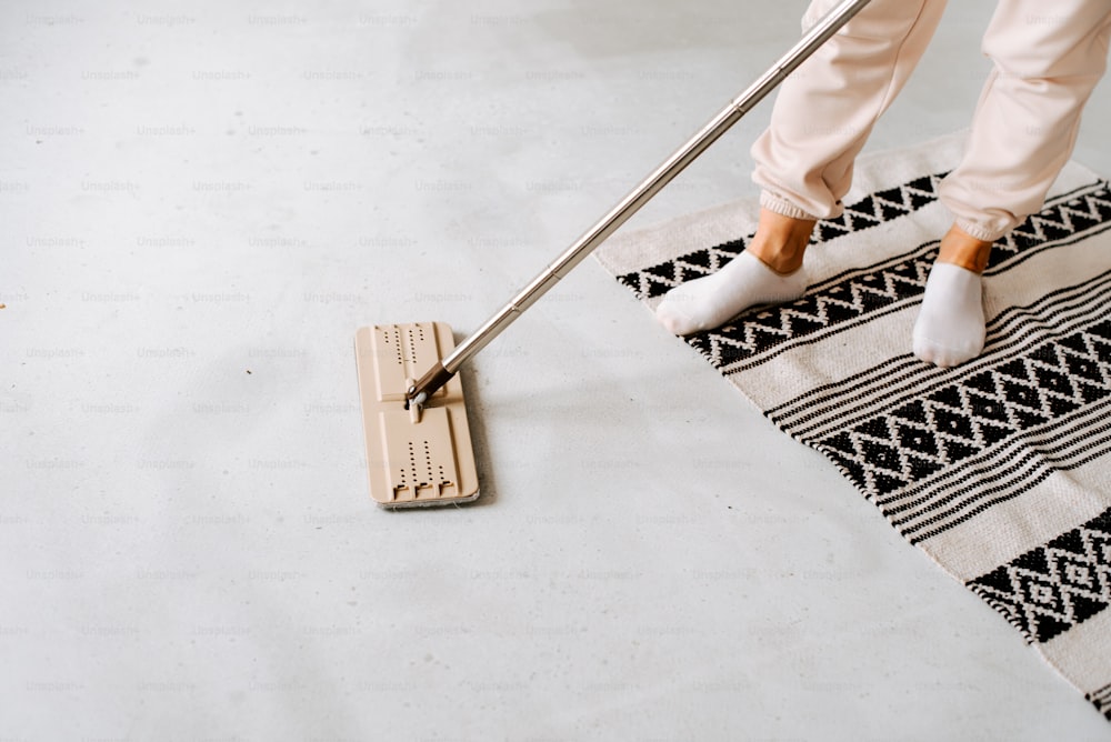 a person with a mop on a rug