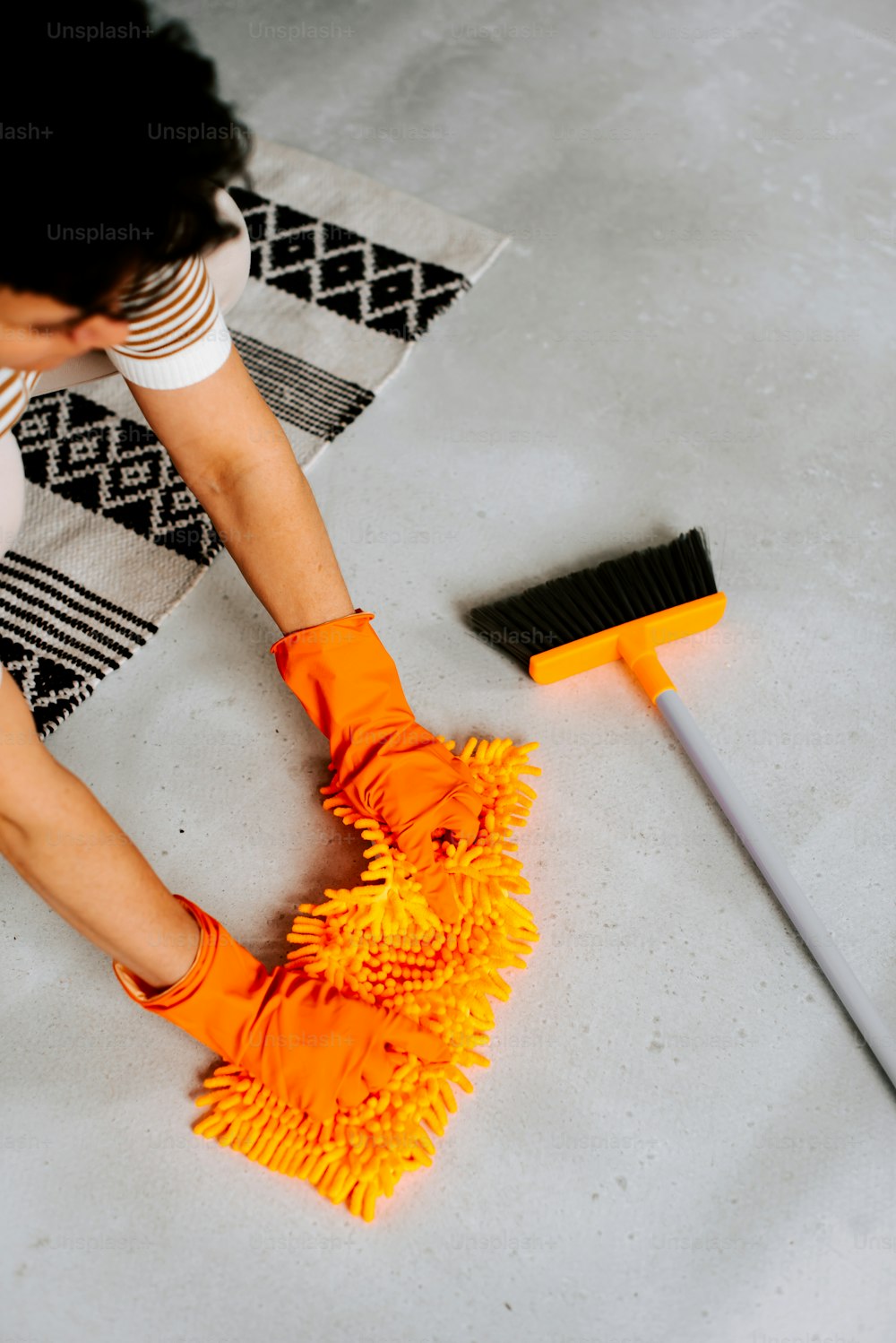 Una mujer está limpiando el piso con una escoba