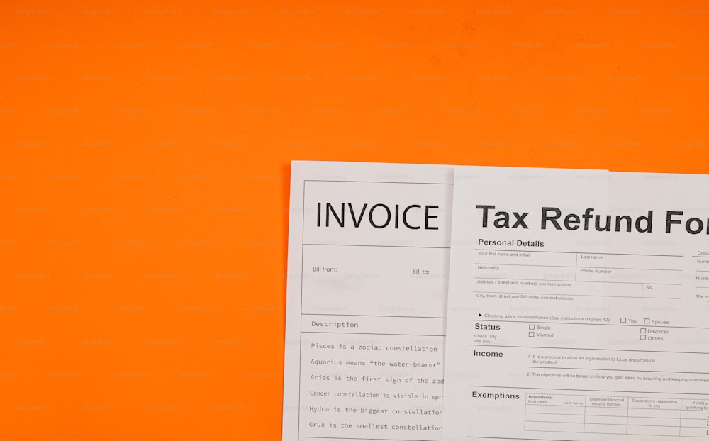 ein Paar Steuerrückerstattungsformulare auf orangefarbenem Hintergrund