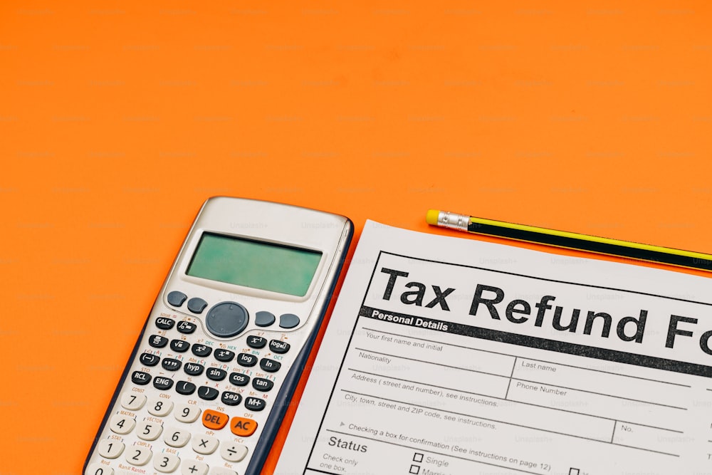 Un formulario de reembolso de impuestos junto a una calculadora y un lápiz