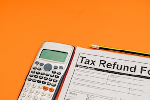 um formulário de reembolso de impostos ao lado de uma calculadora e lápis