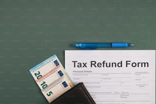 um formulário de reembolso de impostos ao lado de uma caneta e uma carteira
