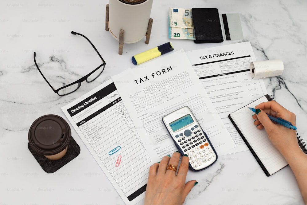 Una persona sentada en una mesa con una calculadora y un cuaderno