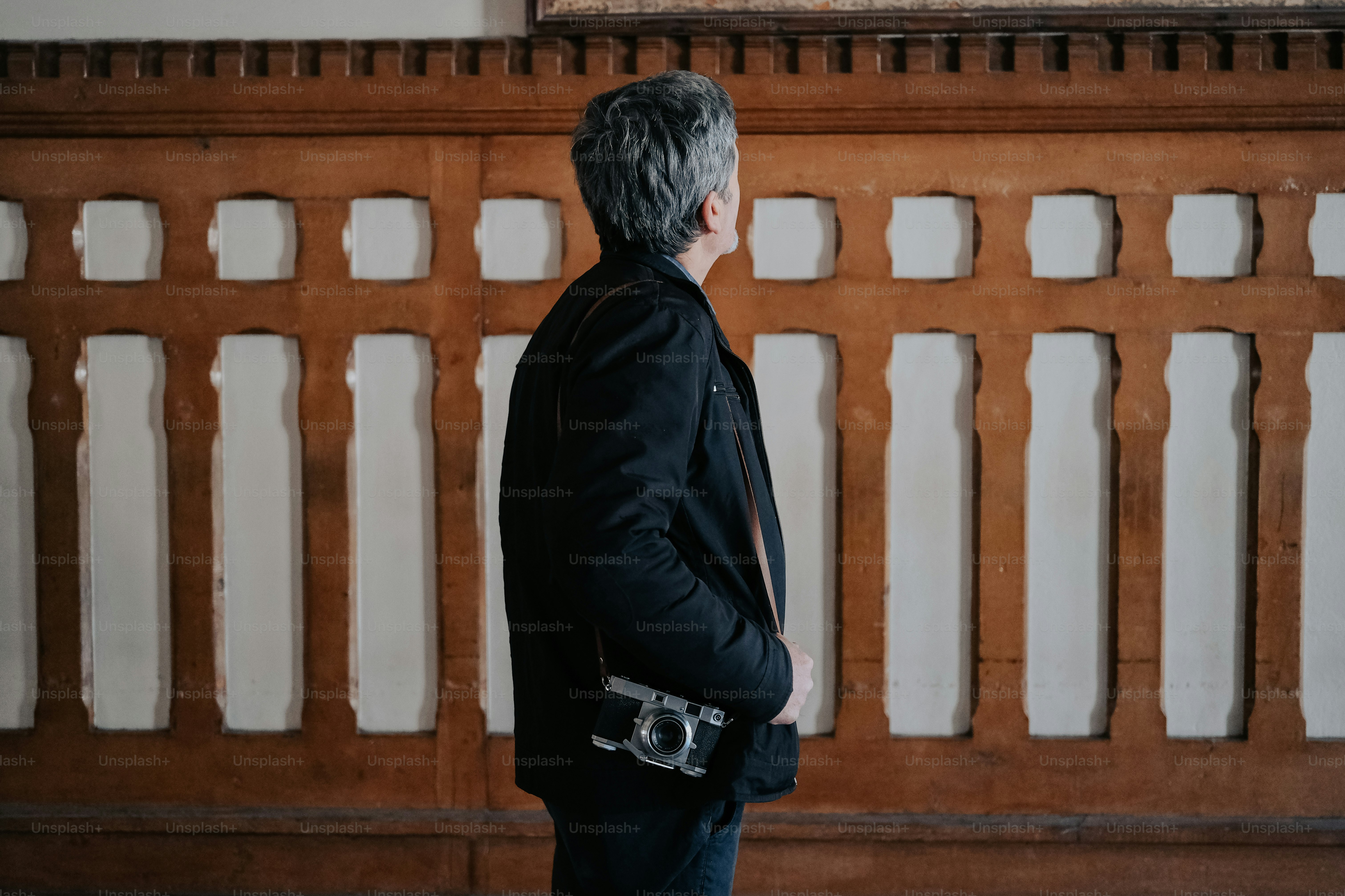 Ein Mann steht vor einer Holzwand