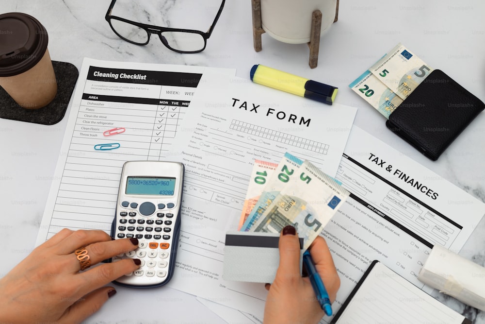 a person holding a calculator next to a tax form