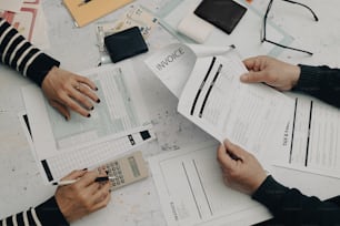 a group of people sitting at a table working on paperwork