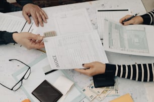 a couple of people sitting at a table with papers