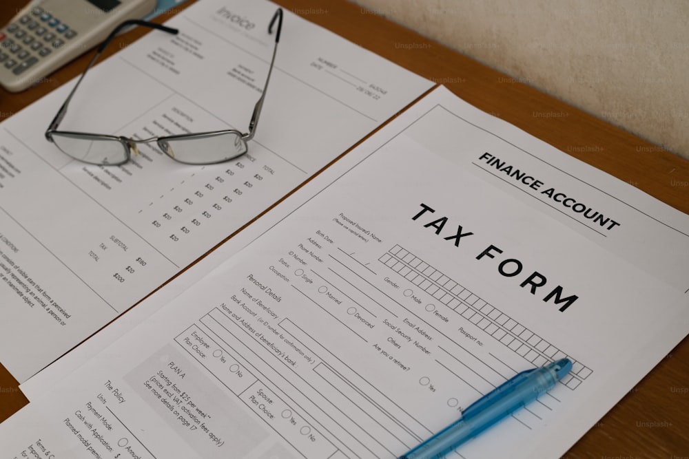 un formulario de impuestos con un bolígrafo y gafas encima