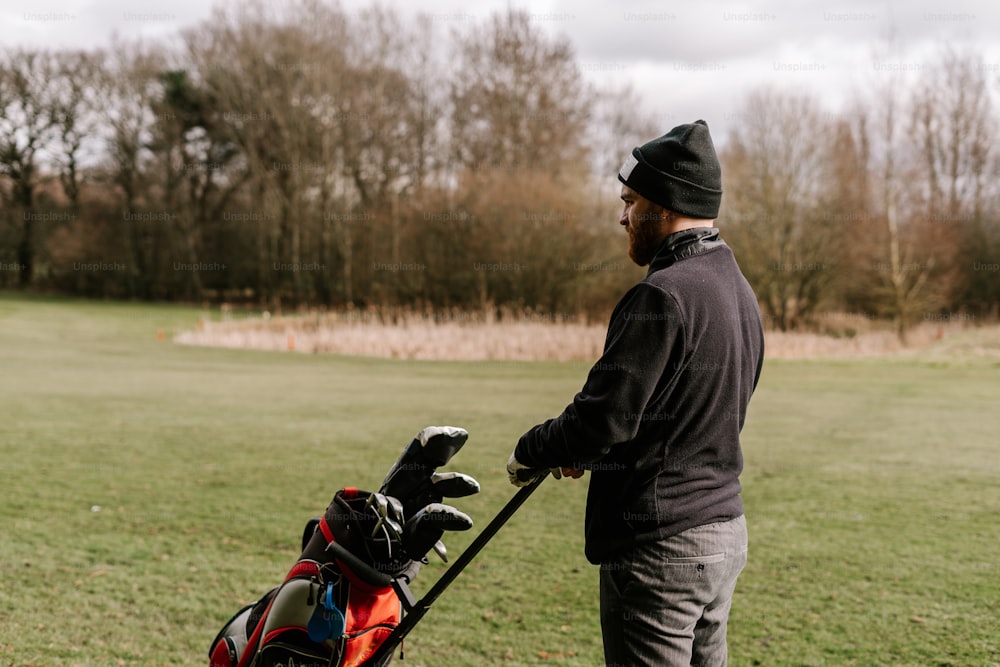 a man holding a golf club and a golf bag