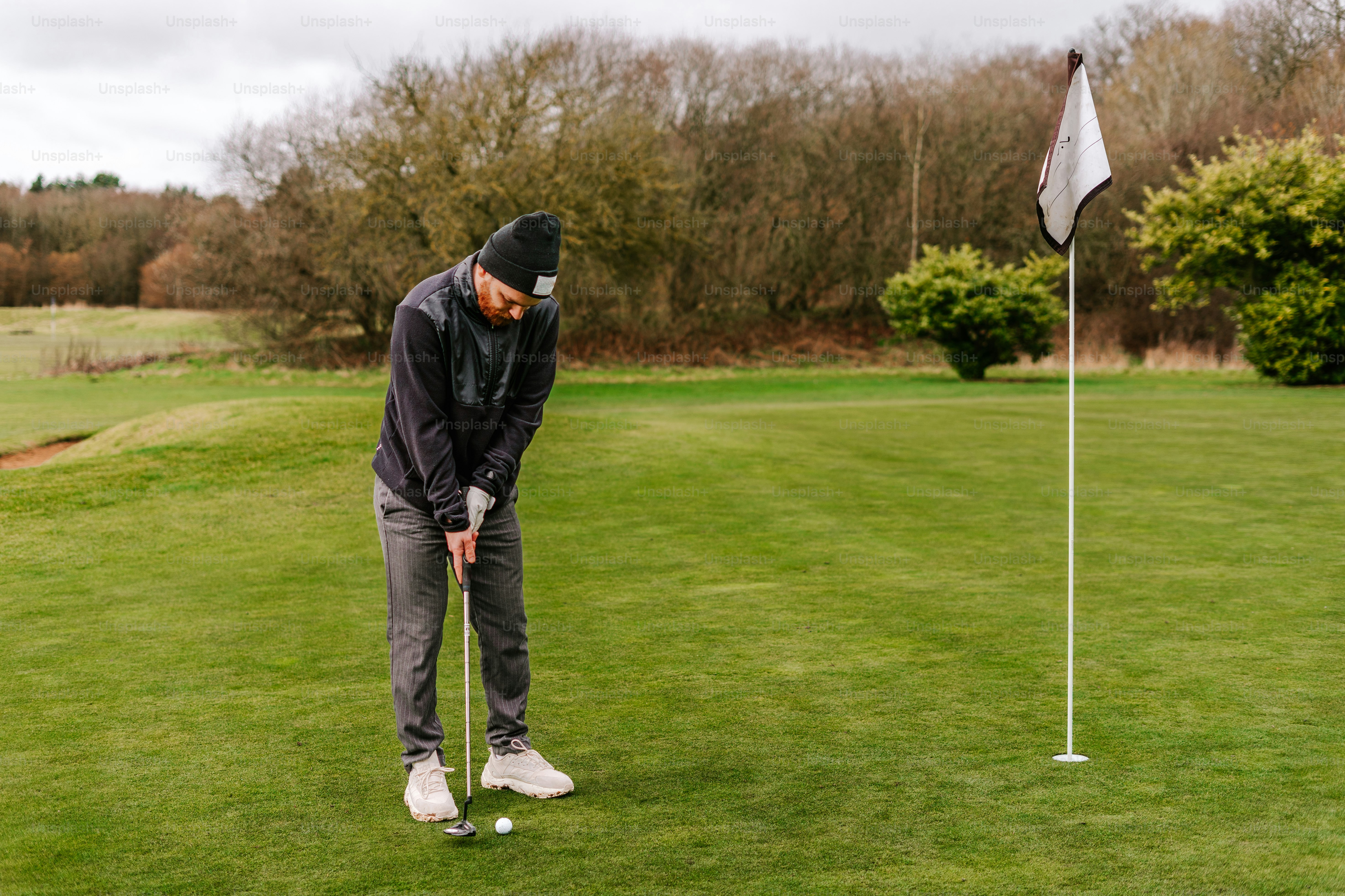 Un hombre poniendo una pelota de golf en un tee