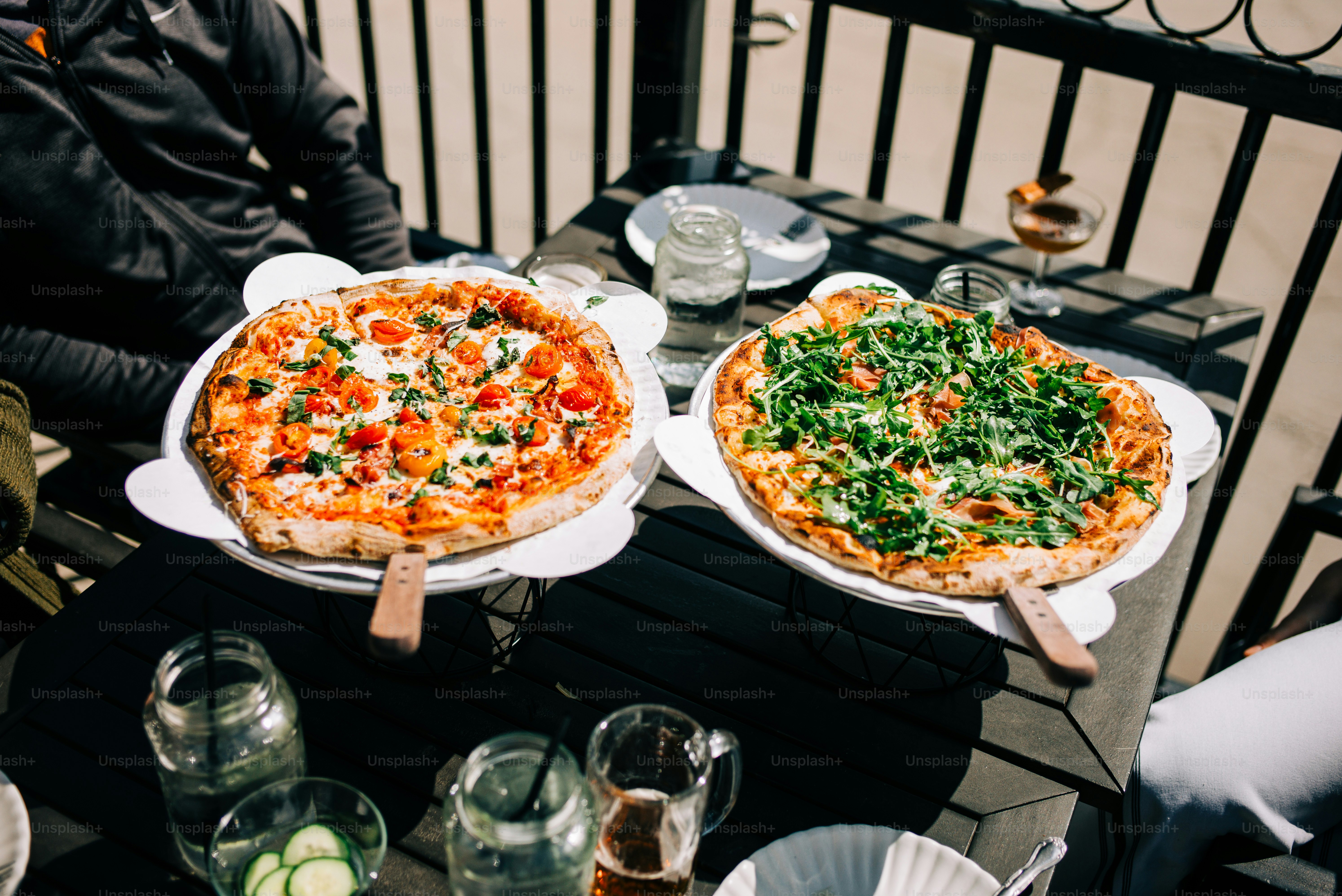 two pizzas sitting on top of plates on a table