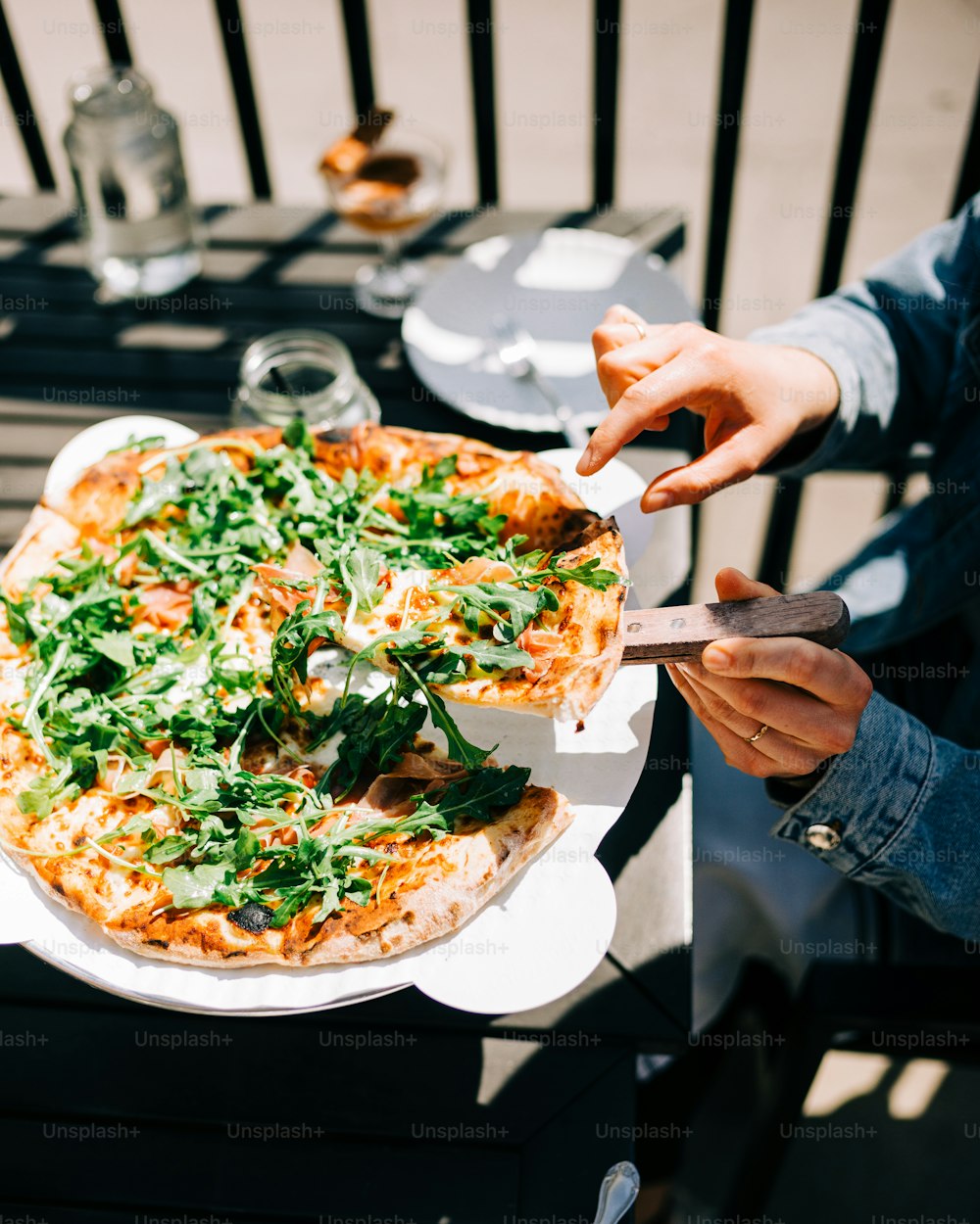 a person cutting a pizza with a knife and fork