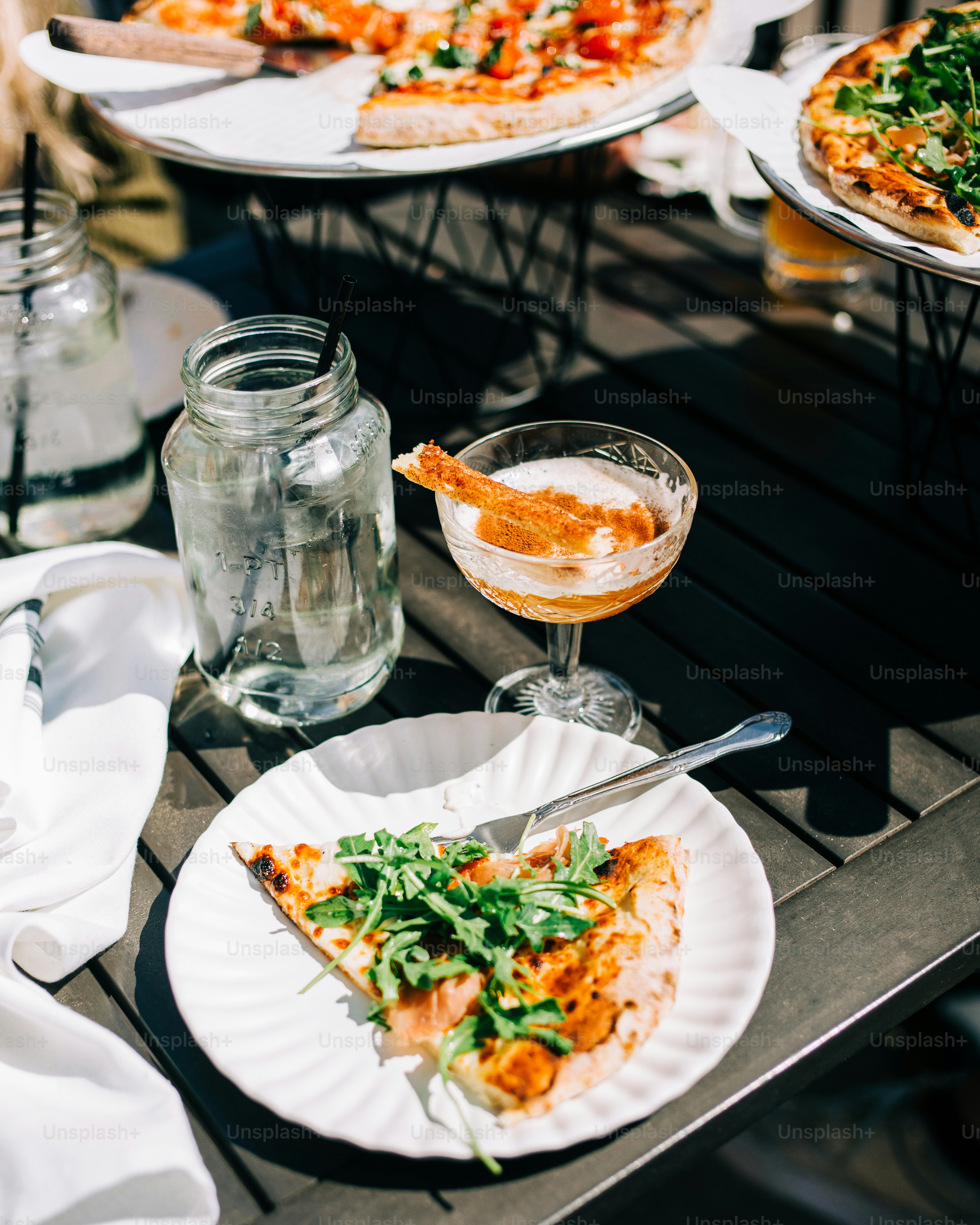 ein Tisch mit Tellern mit Pizza und Getränken