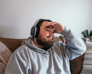 a man sitting on a couch wearing headphones