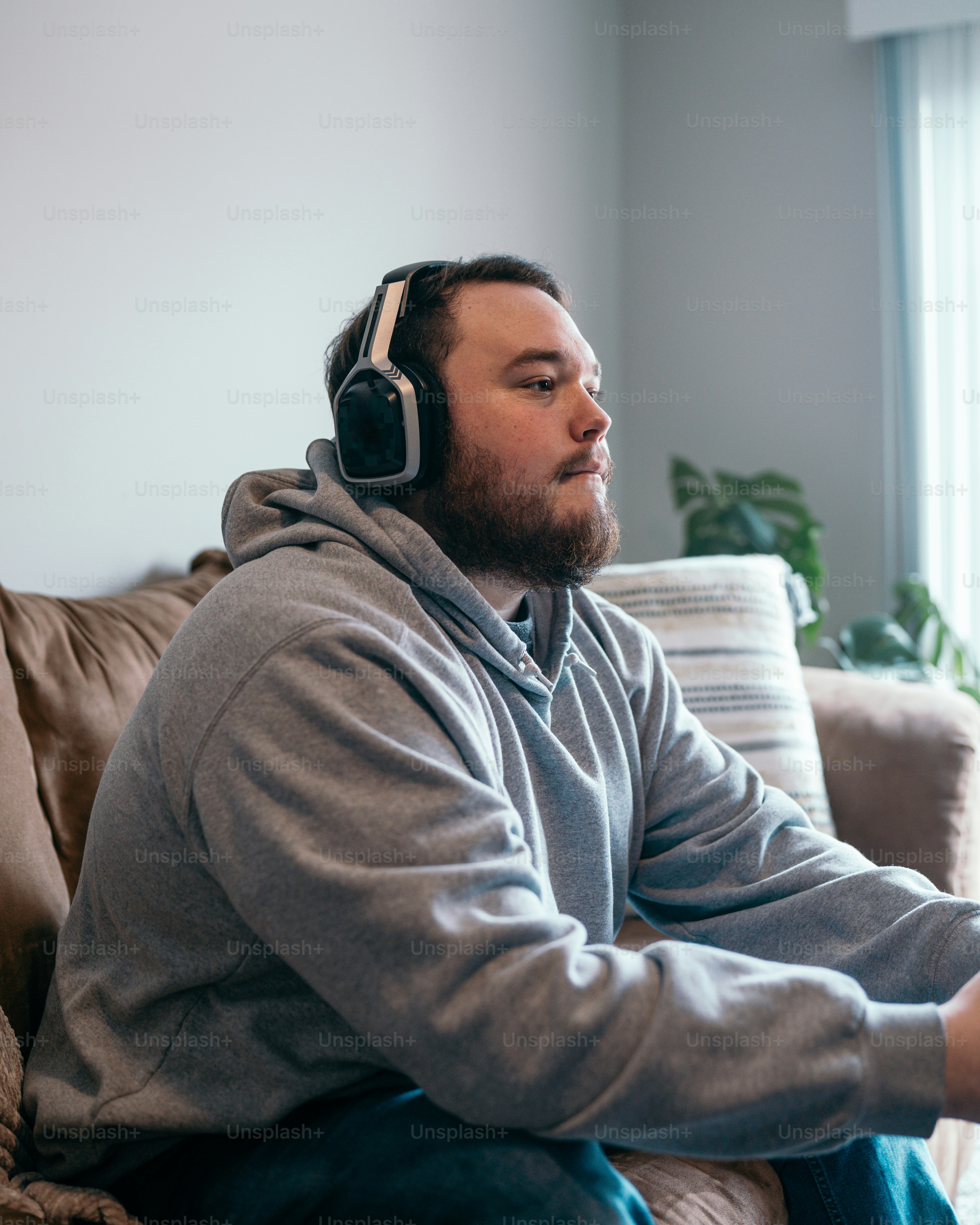 a man sitting on a couch wearing headphones