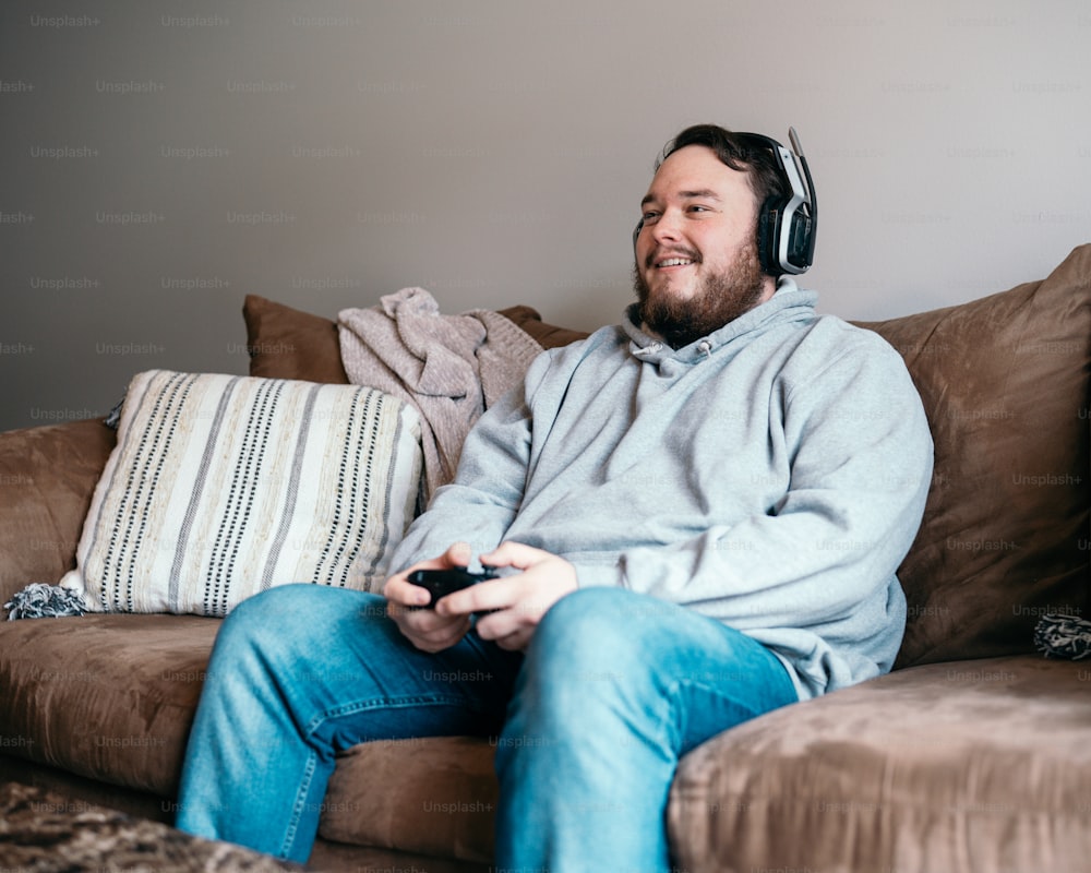 a man sitting on a couch with headphones on