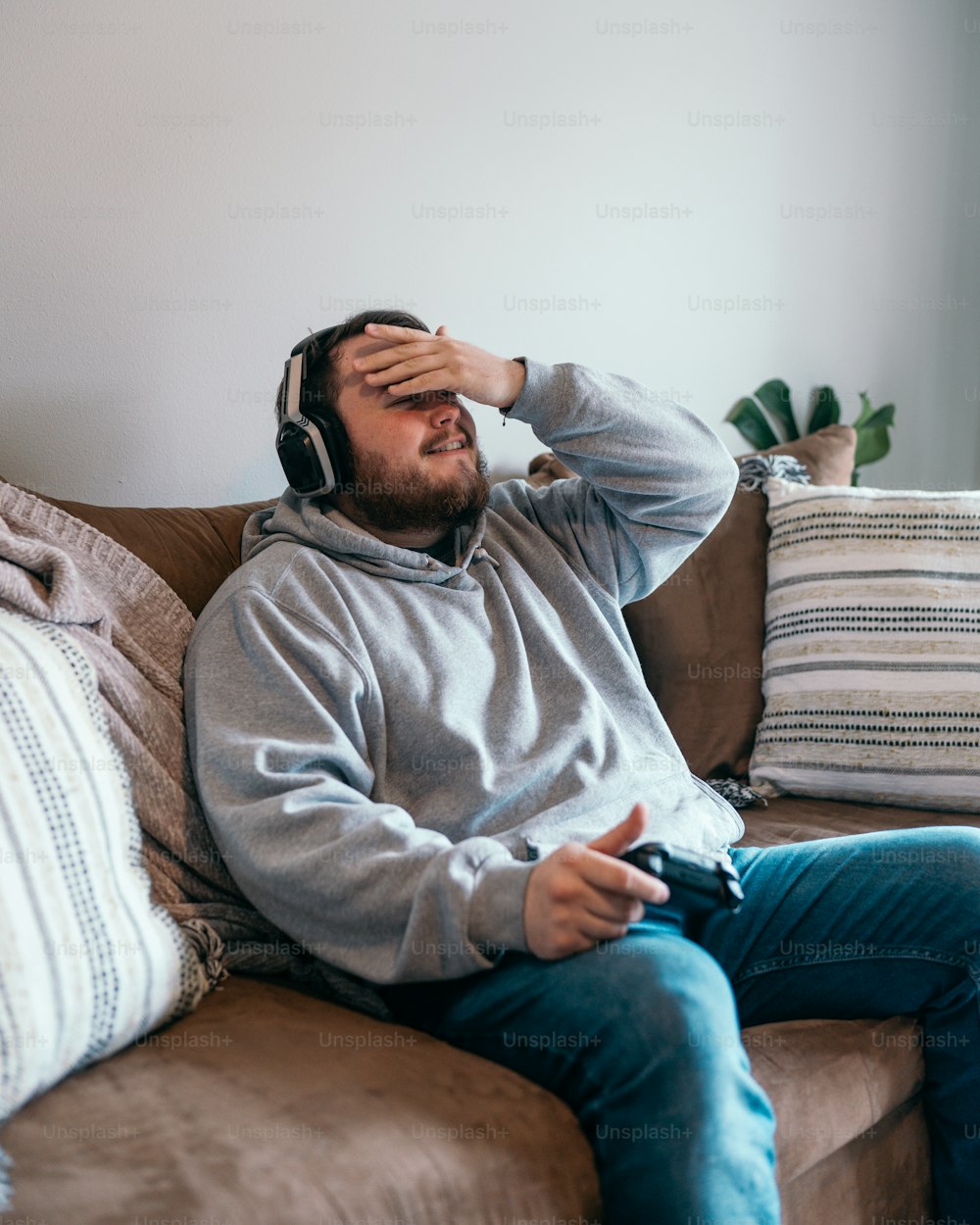 a man sitting on a couch wearing headphones