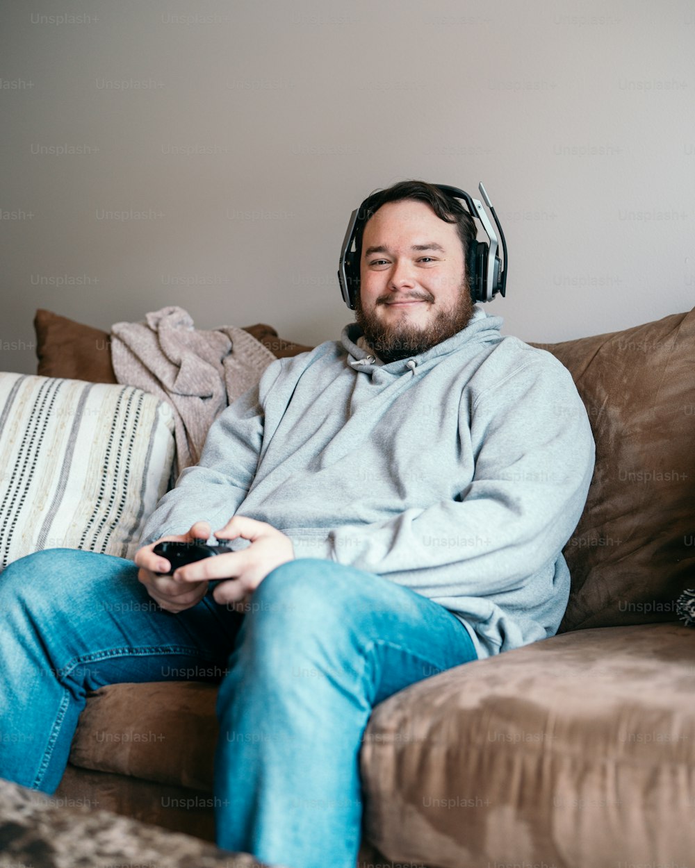 Ein Mann sitzt mit Kopfhörern auf einer Couch