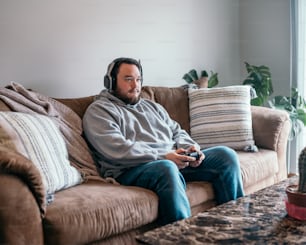 ソファに座ってビデオゲームをしている男性