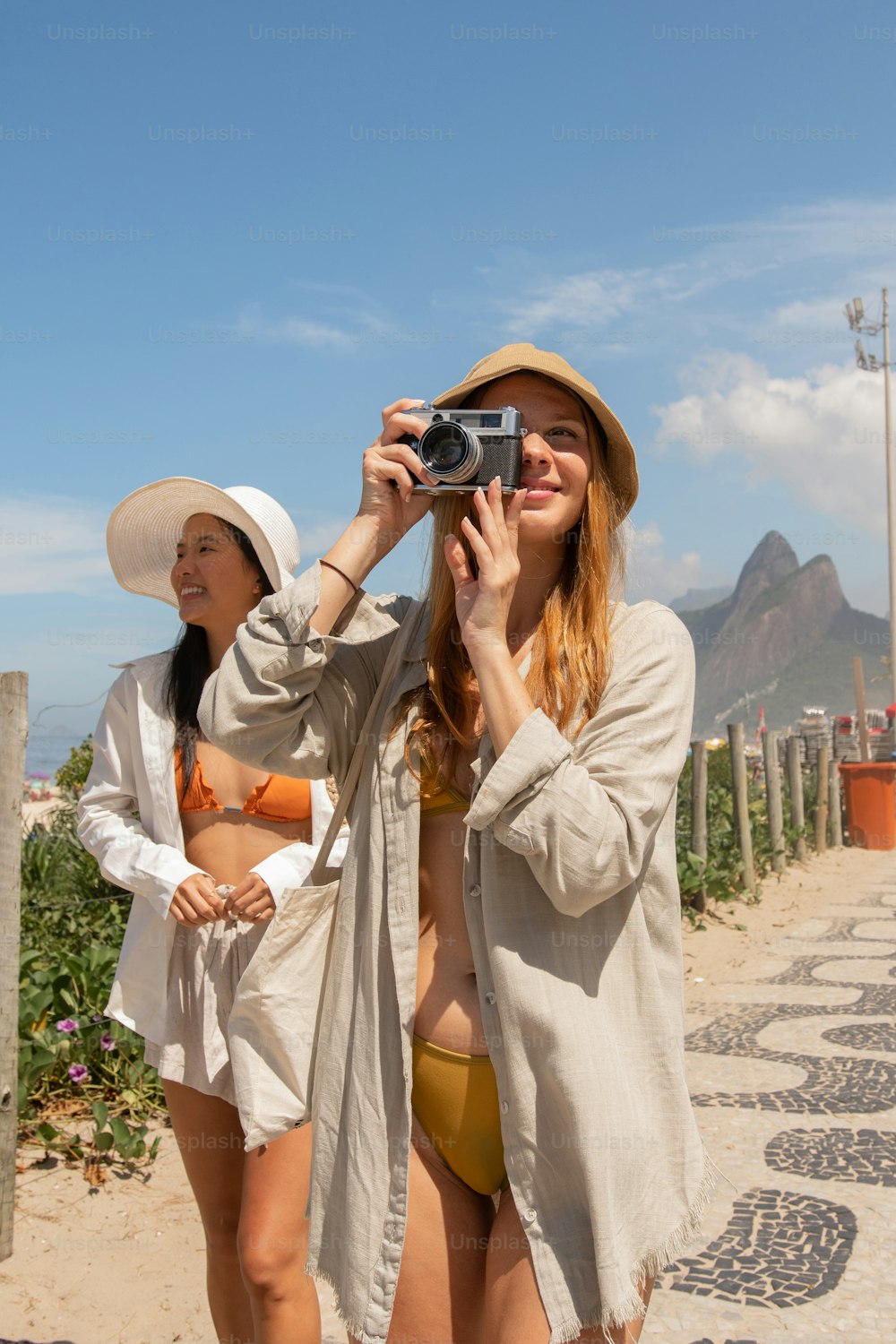 two women in bikinis taking a picture with a camera