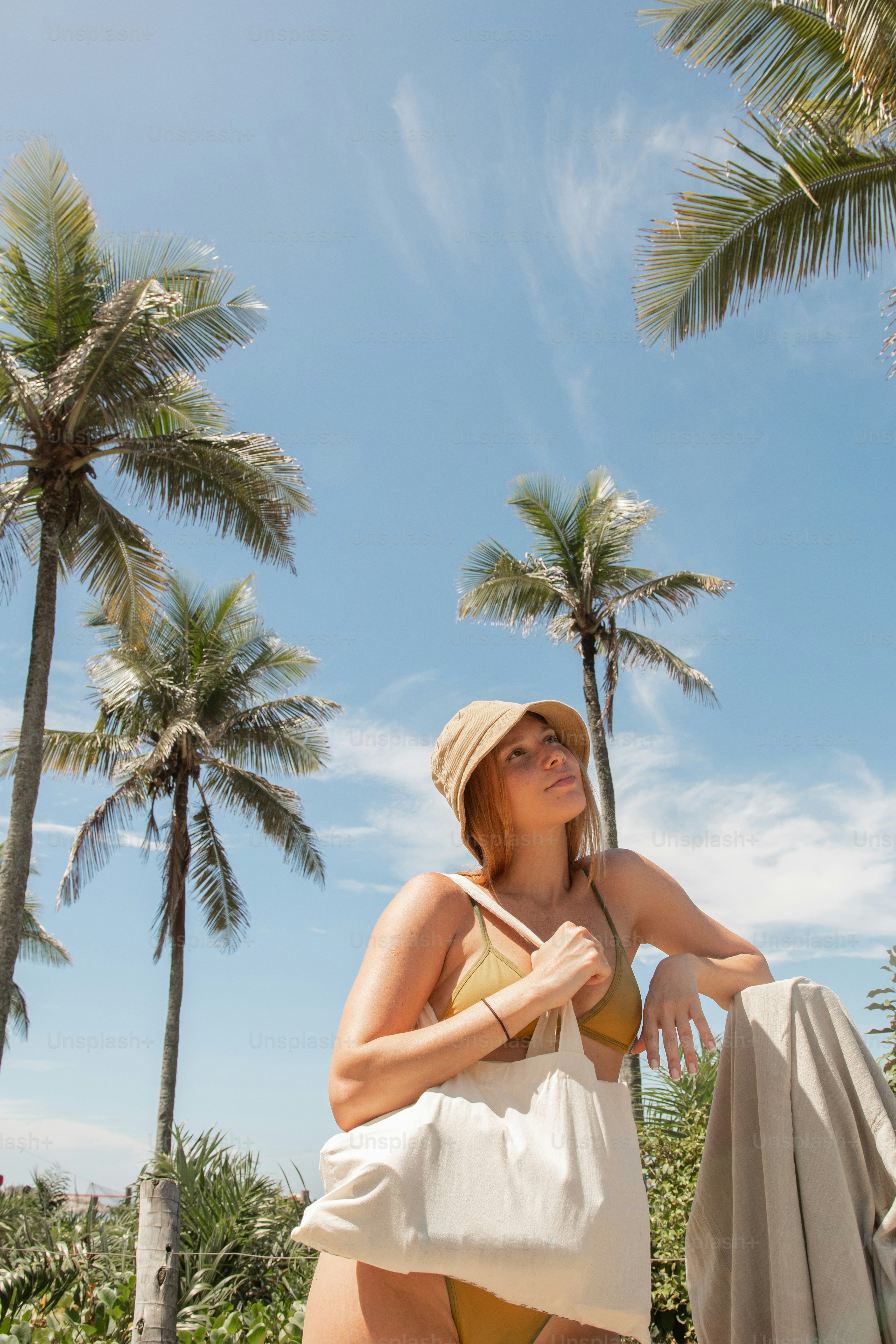 a woman in a bikini holding a white bag