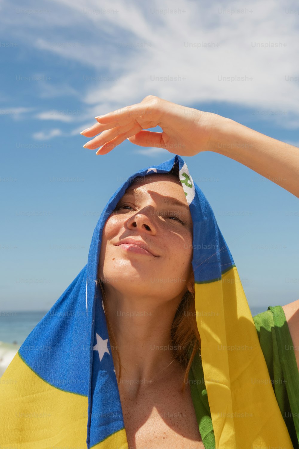 a woman in a yellow and blue towel on the beach