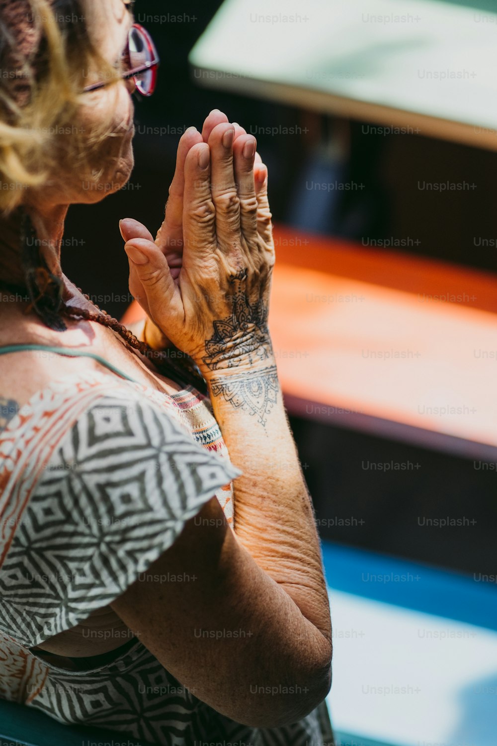 a woman with a tattoo on her arm praying