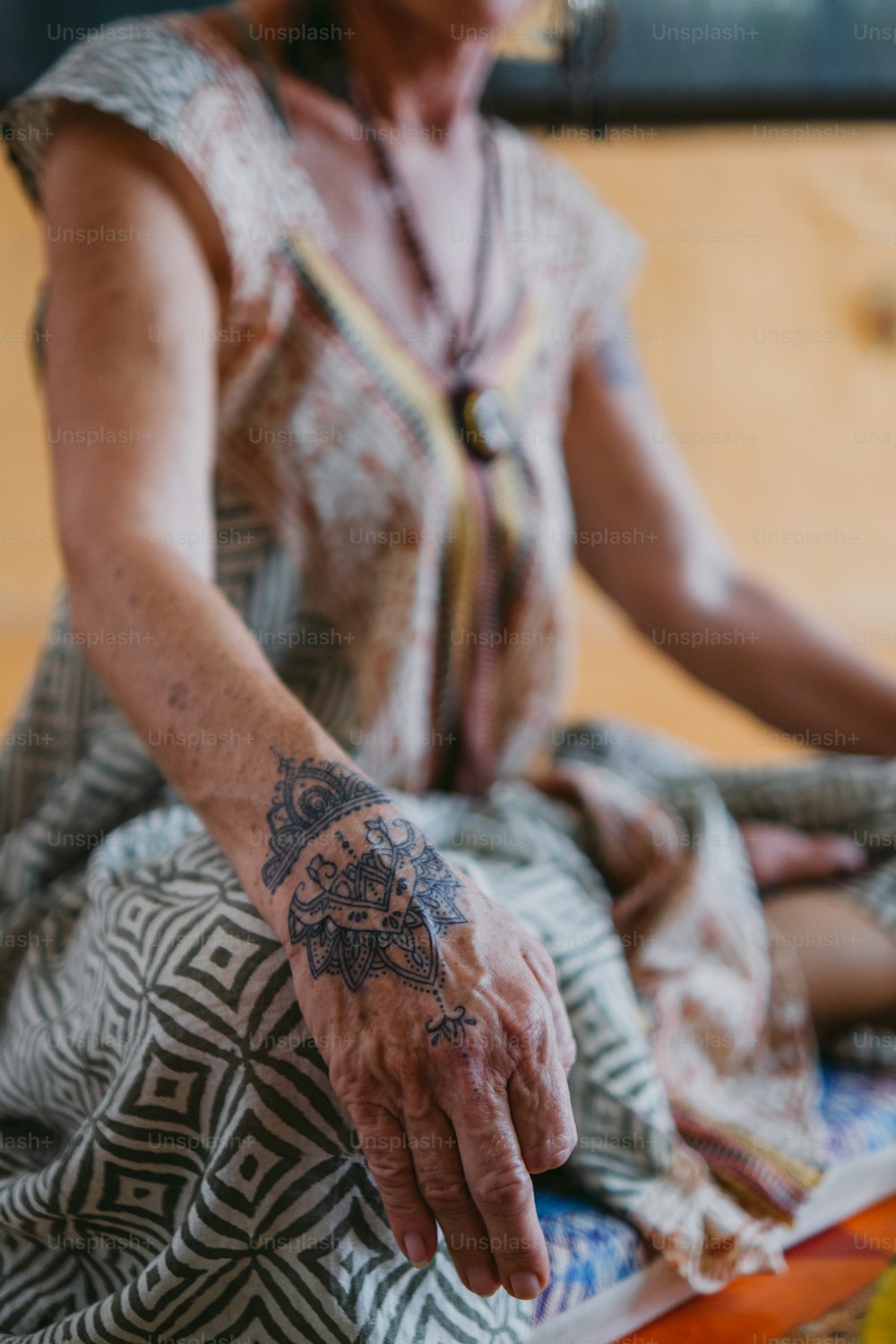 Una mujer sentada en el suelo con un tatuaje en el brazo