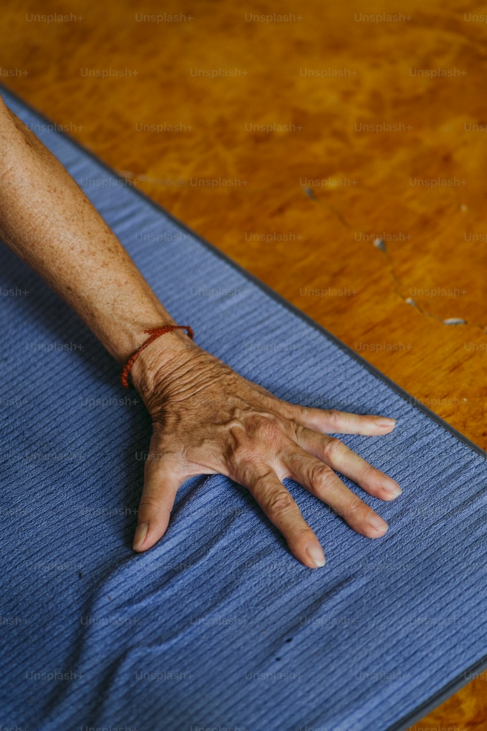 a person's hand resting on a blue mat