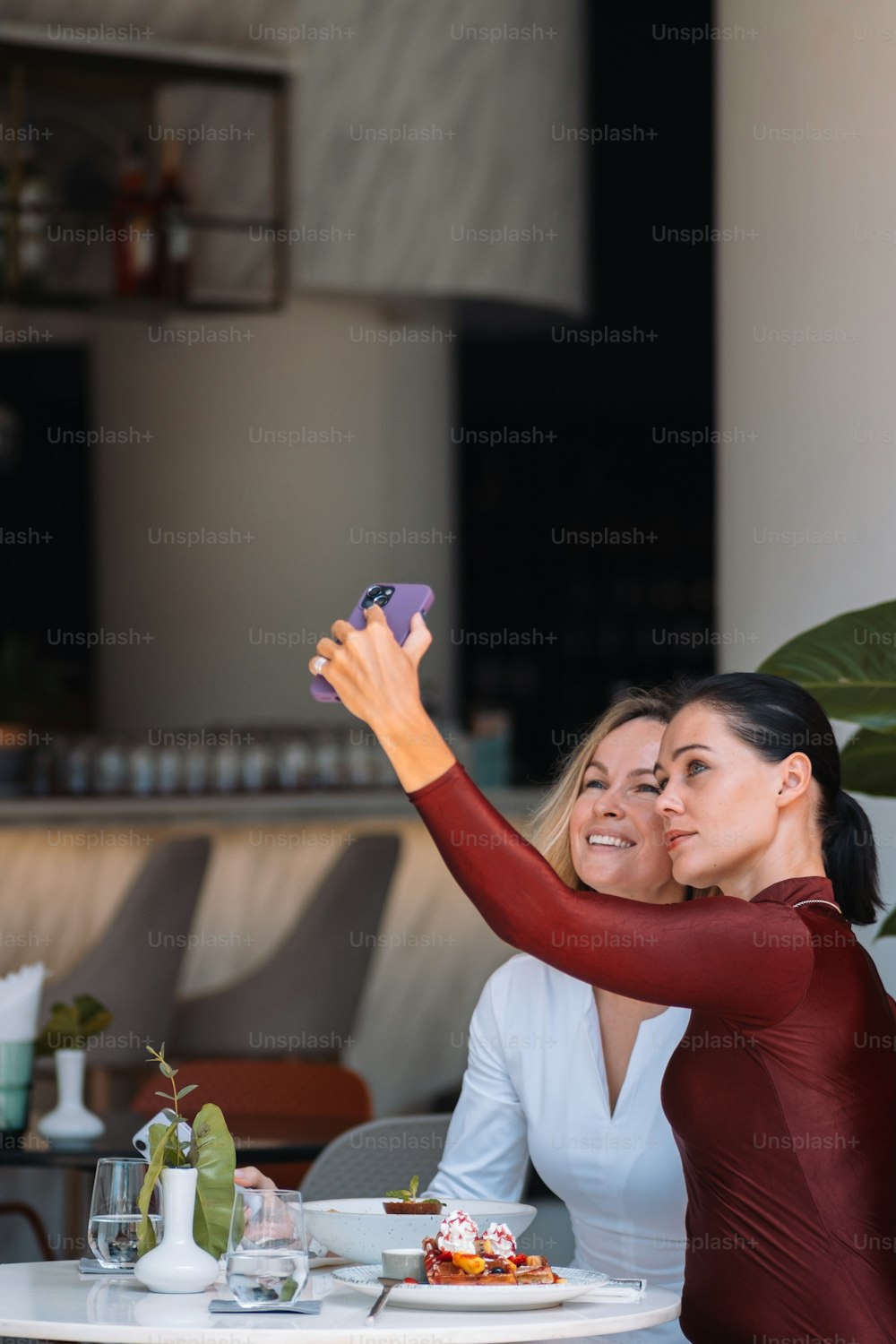 two women taking a picture with their cell phone