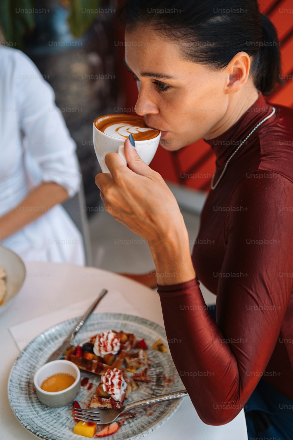 uma mulher sentada em uma mesa comendo comida