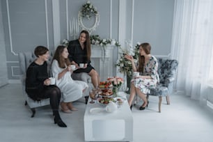 a group of women sitting around a white table