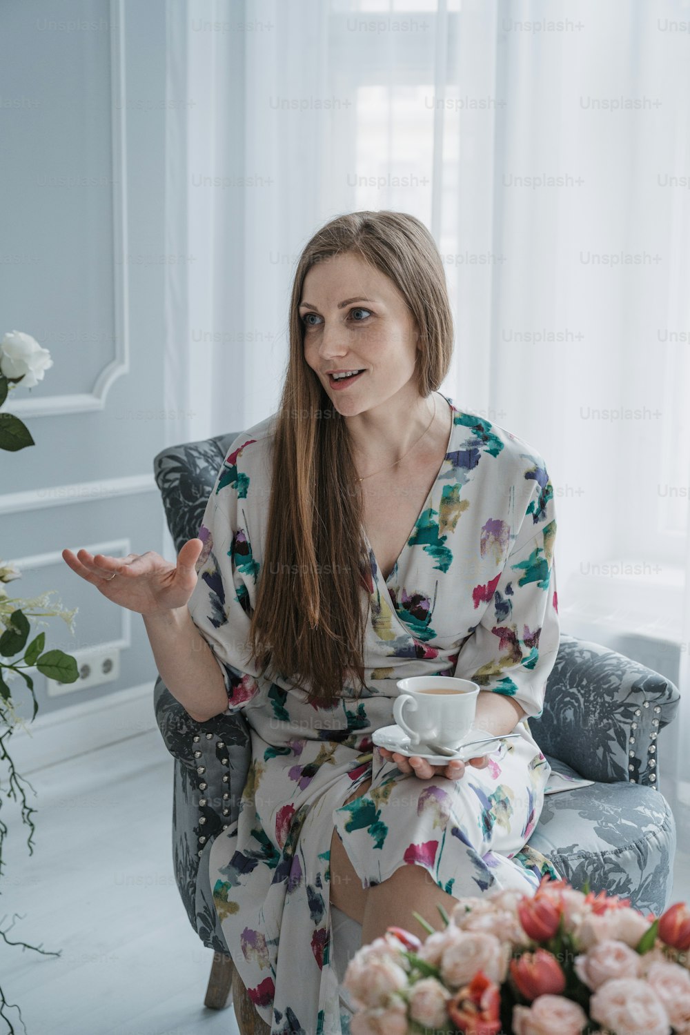 a woman sitting in a chair with a cup of coffee