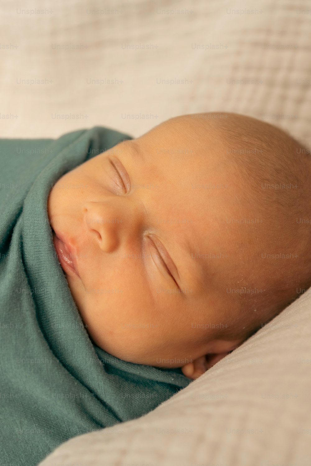 a baby sleeping on top of a blanket