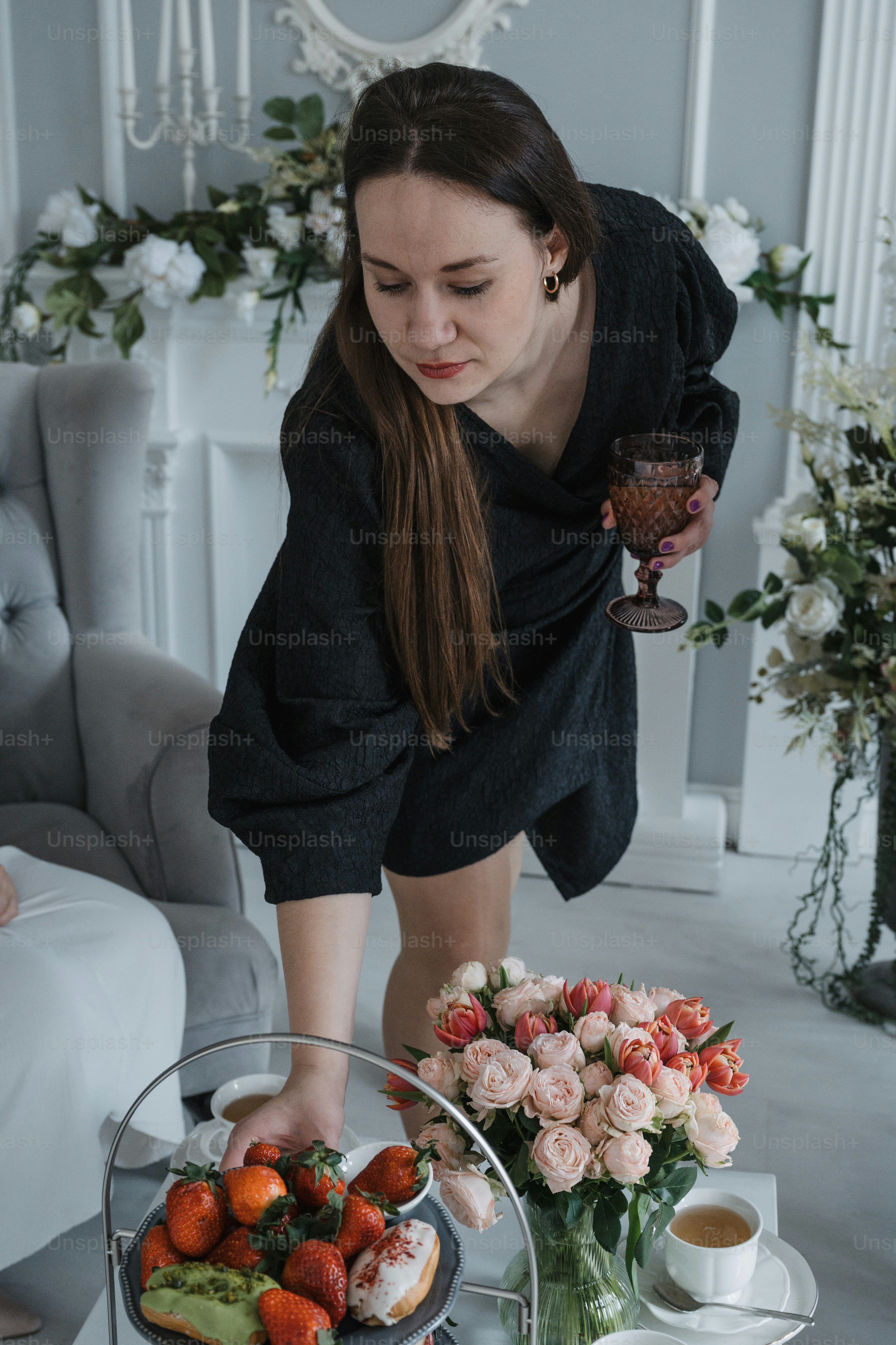 a woman bending over to pick up a piece of fruit