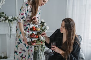 a woman holding a tray of food next to another woman