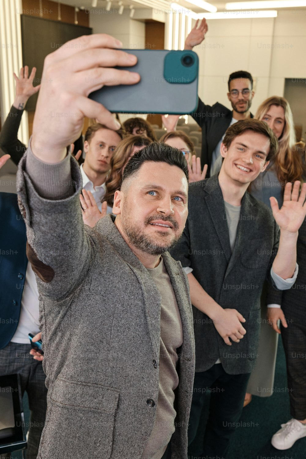 a man taking a selfie with a group of people behind him