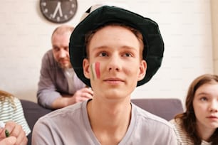 Un jeune homme avec un chapeau vert sur la tête