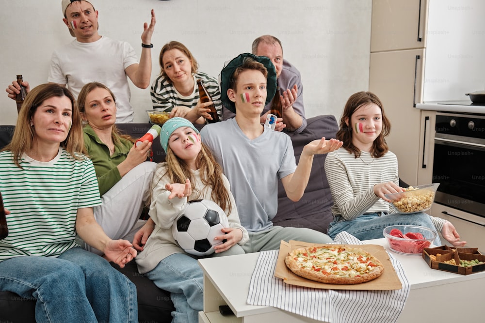 Eine Gruppe von Leuten, die auf einer Couch sitzen und Pizza essen