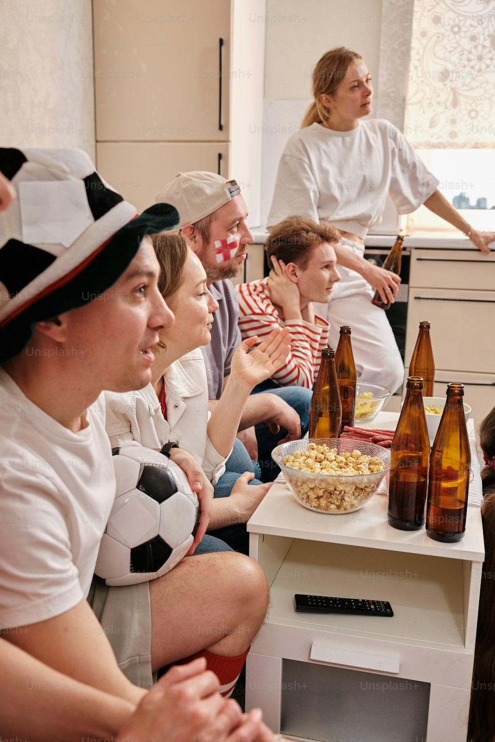 un gruppo di persone sedute intorno a un tavolo con bottiglie di birra